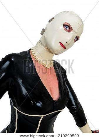 Freaky hooded cosplay woman in black latex rubber catsuit and cream hood. Big blue staring eyes. Creepy doll fetish costume. Portrait with white background.