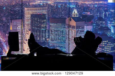 Businessman working in dark room at skyscraper