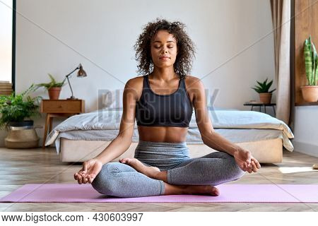 Young Calm Fit Healthy African American Woman Wearing Sportswear Sitting At Home In Bedroom Doing Yo