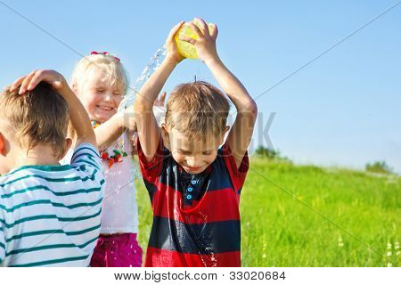 Excited kids spraying water on each other