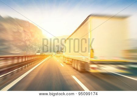 Generic Semi Trucks Speeding On The Highway At Sunset - Transport Industry Concept With Semitruck