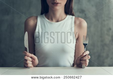 Close Up. Young Woman Sitting With Knife And Fork. Diet Concept. Weight Loss Problem. Starving Young