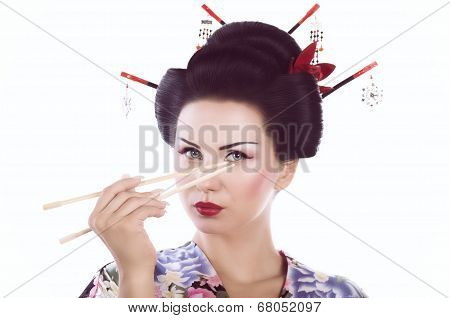 Young woman in Japanese kimono with chopsticks and sushi roll, isolated on white background.