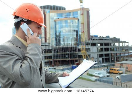 Industrial theme: constructor standing at a site area.