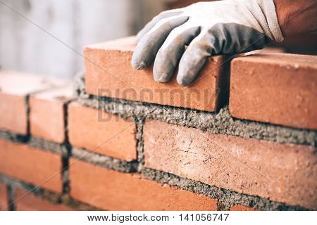 Close Up Of Industrial Bricklayer Installing Bricks On Construction Site