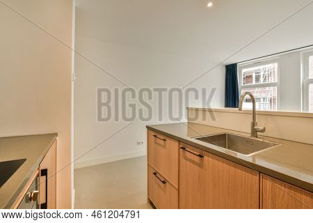 Contemporary Counters And Stools Located Under Stylish Exhaust Hood In Spacious Light Kitchen At Hom