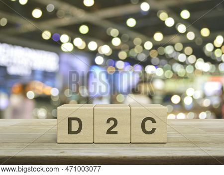 D2c Acronym On Wood Block Cubes On Wooden Table Over Blur Light And Shadow Of Shopping Mall, Direct 