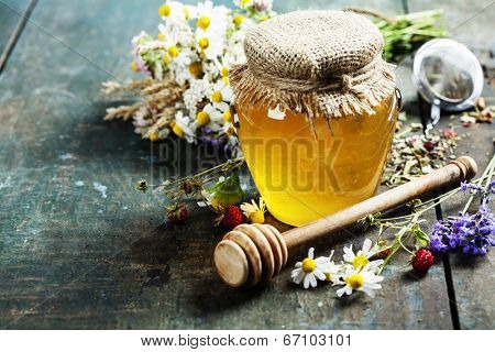 Honey and Herbal tea on wooden background - summer, health and organic food concept