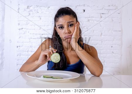 Depressed Dieting Woman Holding Folk Looking At Small Green Vegetable On Empty Plate