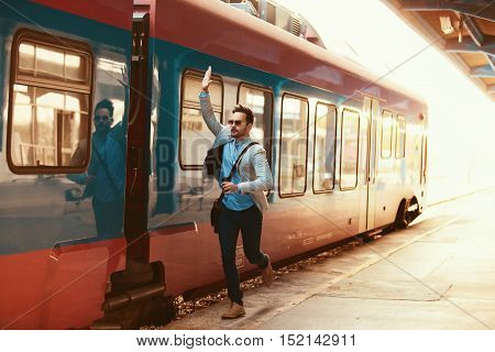 Young businessman is late for train. He is running.