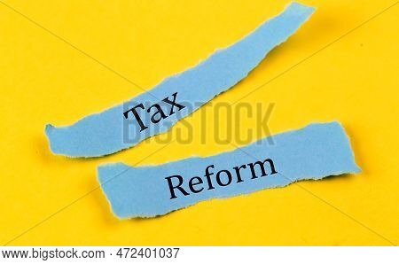 Tax Reform Text On Blue Pieces Of Paper On Yellow Background, Business Concept