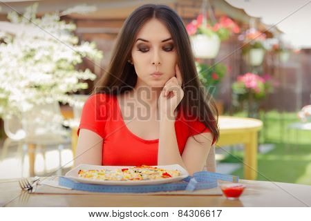 Young Woman Thinking About Eating Pizza on a Diet