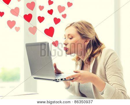 virtual relationships, online dating and social networking concept - woman sending kisses with laptop computer