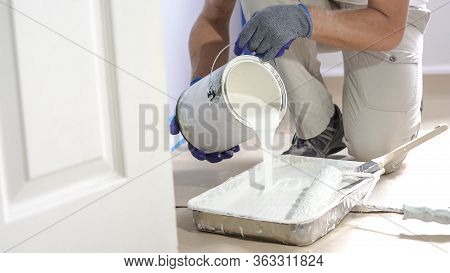 Professional Interior Construction Worker Pouring White Color Paint To Tray.