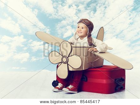 Little Child Playing Airplane Pilot, Kid Traveler Flying In Aviator Helmet On Travel Suitcase