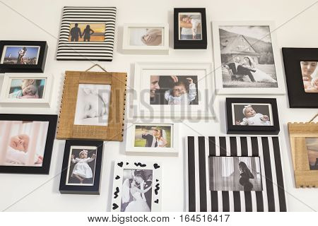 white wall with photos of the family in various photo frames