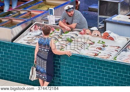 Voronezh, Russia, 23.08.2019 - Fish Seller In Local Market. Man Fishmonger Discuss Fish Trade With C