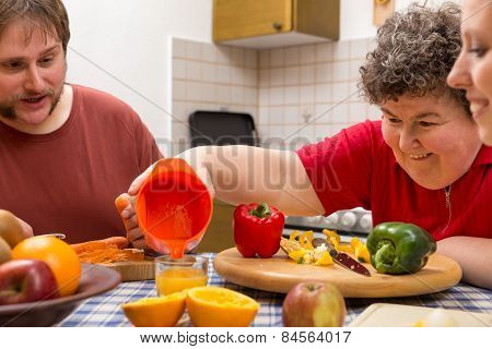 Mentally Disabled Woman And Two Caretakers Cooking Together