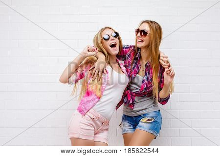 Fashion portrait of two friends posing. modern lifestyle.two stylish sexy hipster girls best friends ready for party.Two young girl friends standing together and having fun.