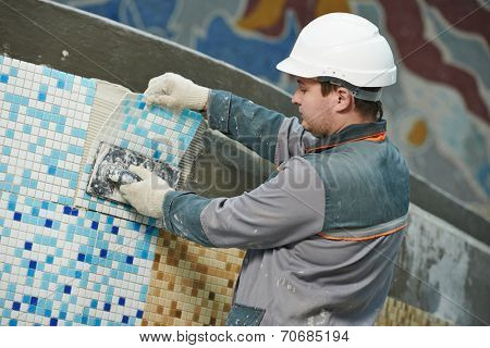 industrial tiler builder worker installing floor tile at repair renovation work