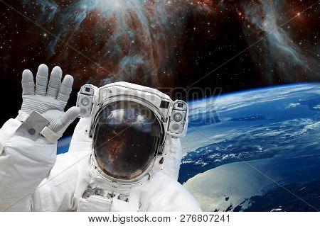 Astronaut In Outer Space In Spacesuit Against The Background Of The Earths Blue Orbit And Space With