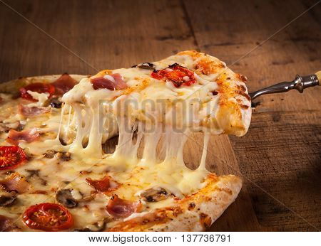 A slice of hot pizza just from the oven with melted cheese dripping