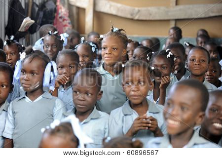 KOLMINY, HAITI - FEBRUARY 12, 2014: Editorial image of unidentified children in a crowded classroom in Kolminy, Haiti on February 12, 2014.  Shallow depth of field with focus on center girl.