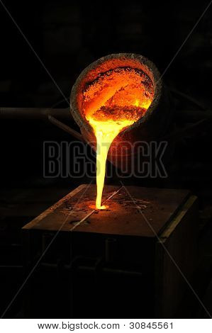 Foundry - molten metal poured from ladle into mould - lost wax casting