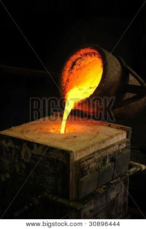 Foundry - molten metal poured from ladle into mould