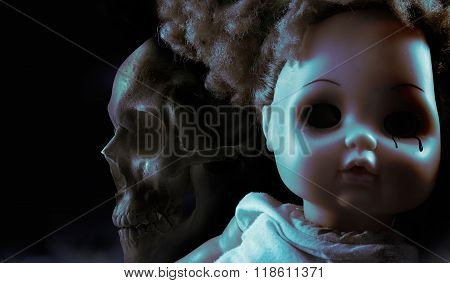 Scary horror plastic doll face with black tears and human skull on background.