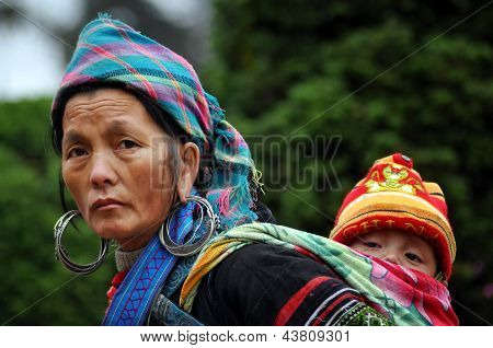 Mulher negra Hmong, levando seu filho, em Sapa, Vietname