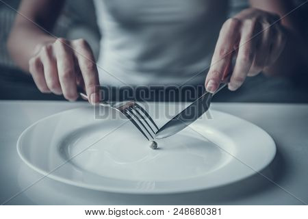 Close Up. Woman Eating One Pea With Fork And Knife. Diet Concept. Weight Loss Problem. Starving Youn