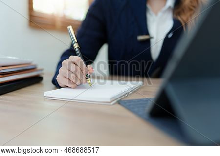 Portrait Of A Young Asian Man Showing A Smiling Face As She Uses His Notebook, Tablet Computer And F