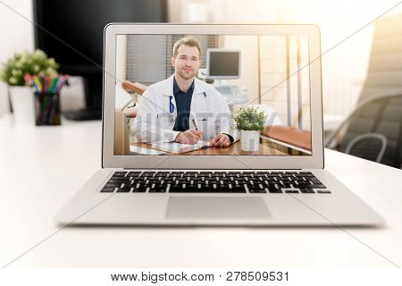 Doctor With A Stethoscope On The Computer Laptop Screen. Telemedicine Or Telehealth Concept.