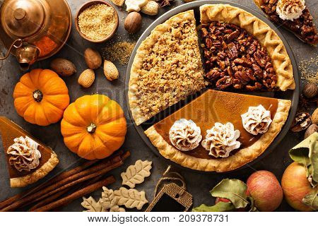 Fall traditional pies pumpkin, pecan and apple crumble pie overhead shot