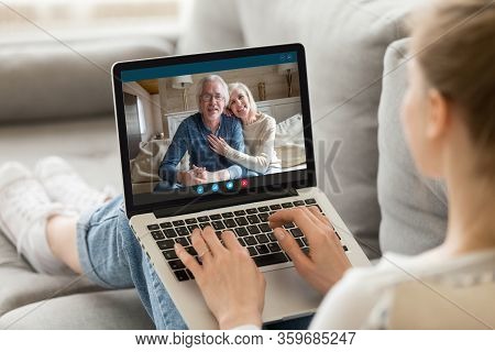 Elderly Grandparents Communicating With Adult Granddaughter Using Video Call App