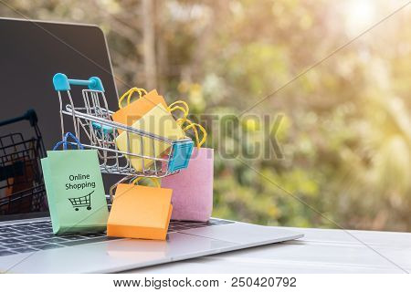 Colorful Paper Bags Are In Trolley On Laptop Keyboard. Consumers Can Buy Products Directly  From A S