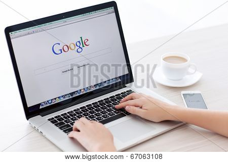 Macbook Pro Retina And Iphone 5S With Google Home Page On The Screen And Female Hands In A White Roo