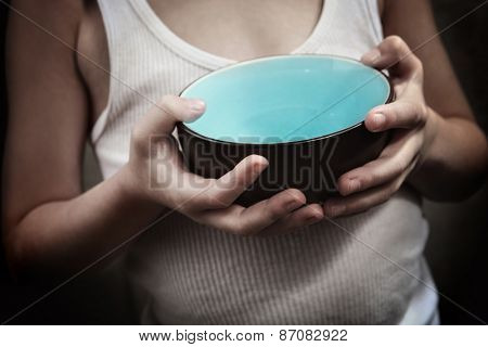 Child's hands holding an empty bowl.  Hunger 