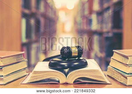 Old book in library with judge gavel on open law textbook in court archive text collection study room for copyrights day and international legal rights concept