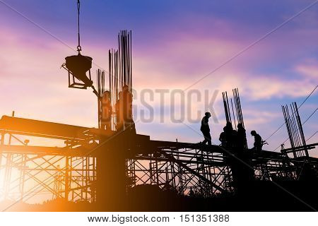 Silhouette construction industry engineer standing orders for construction team to work safely on high ground over blurred background sunset pastel for industry background. heavy industry concept.