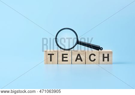 Wooden Blocks With The Text: Teach With Magnifying Glass. Business Concept