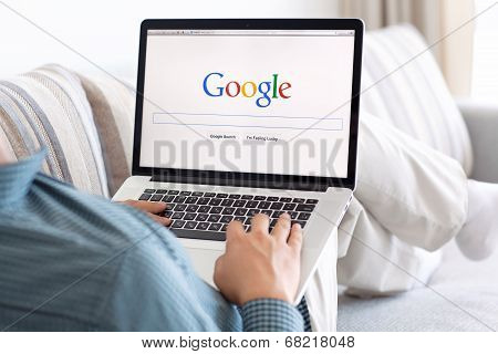 Man Sitting At The Macbook Retina With Site Google On The Screen