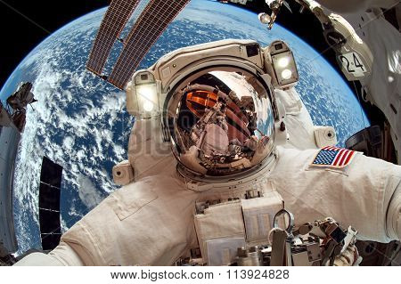 International Space Station and astronaut in outer space over the planet Earth. Elements of this image furnished by NASA.