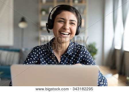 Cheerful Indian Woman Wear Wireless Headset Laughing With Laptop