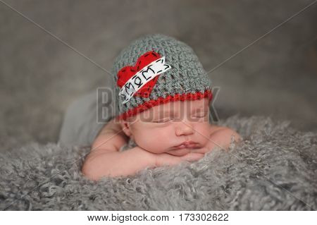 Two week old sleeping baby boy wearing a crocheted 