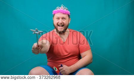 A Youna Young Bearded Freaky Man In A Pink T-shirt With A Diadem On His Head Riding A Unicorn With A