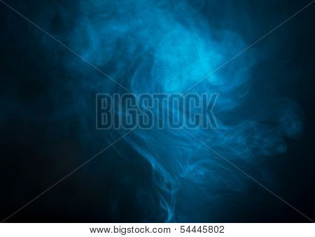 Blue smoke over black studio background