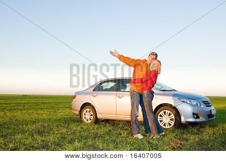 Happy young couple with their new car