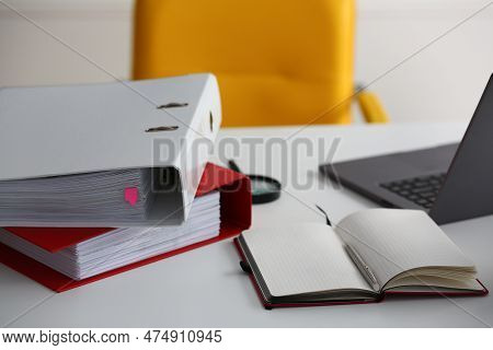 Leather Yellow Armchair And Laptop With Folders At Workplace In Office. Organization Of Workplace At